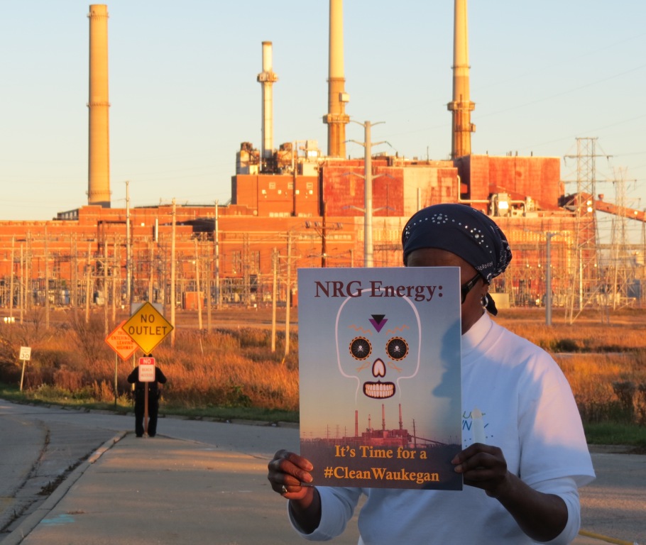 Woman with #CleanWaukegan sign protests in front of NRG coal plant
